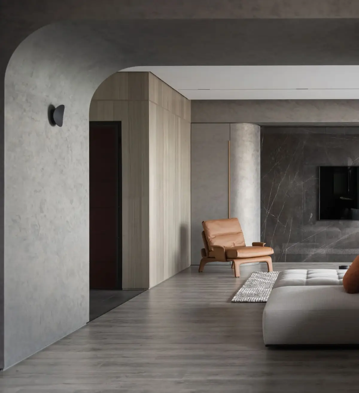 Living met sculpturale boog in grijze metallic afwerking en cognac fauteuil