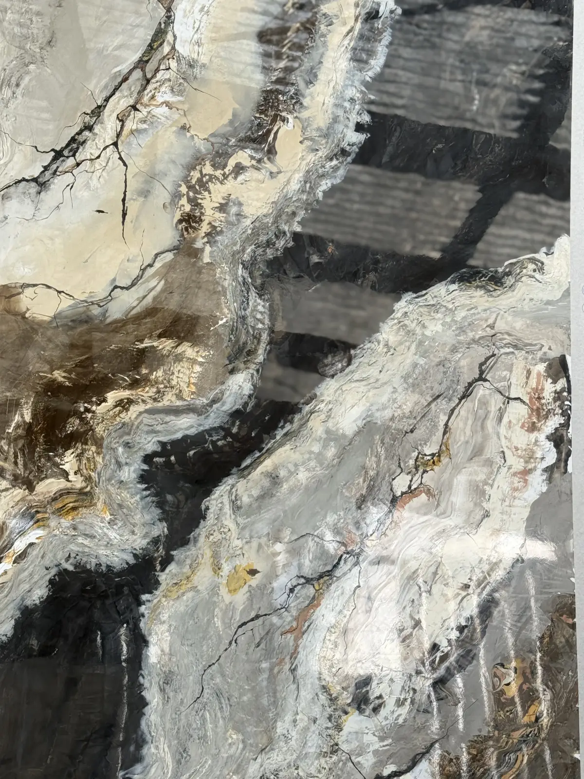 Detail van handgezette marmerimitatie in crème, zwart en warme metallic accenten
