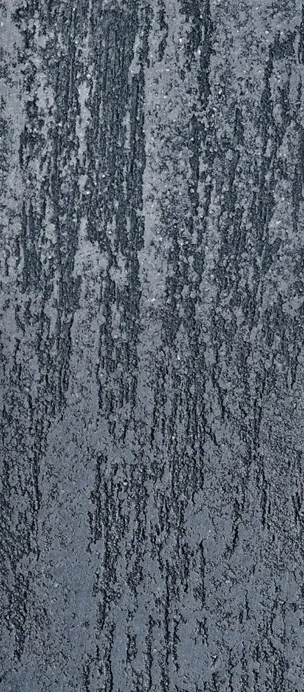 Macro detail van donkergrijze minerale pleister met grove korrel