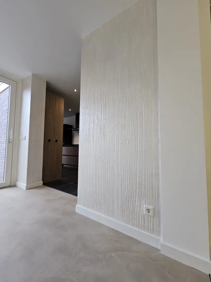 Metallic wandafwerking in een doorgang met warme lichtwerking